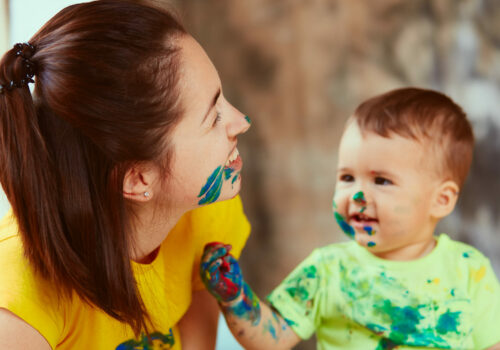 The mother with son painting a big paper by hands