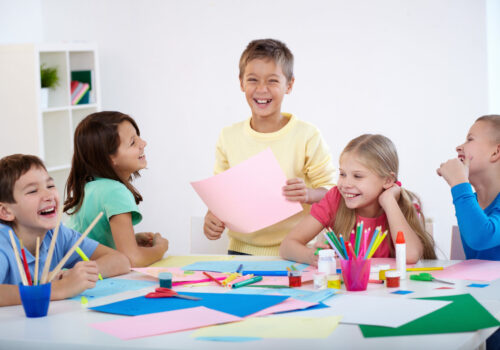 Little boy and his friends laughing in classroom