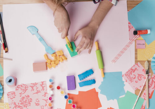 top-view-woman-cutting-colorful-clay-paper (1)