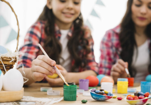 blurred-mother-daughter-painting-easter-eggs-table blurred-mother-daughter-painting-easter-eggs-table
